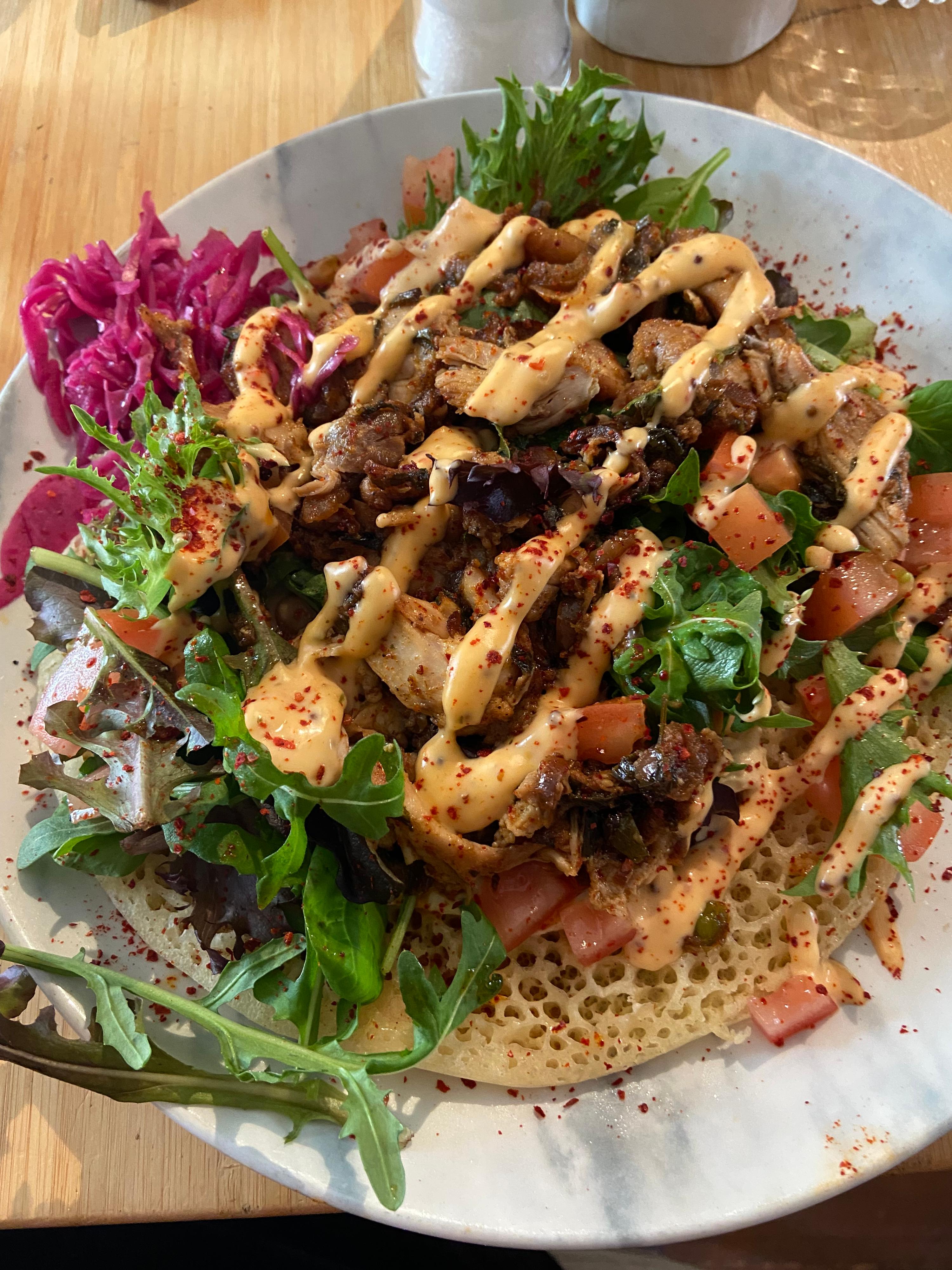 Marokkaanse baghrir met hummus, gemengde salade, gemarineerde kippendij en kimchi-mayonaise