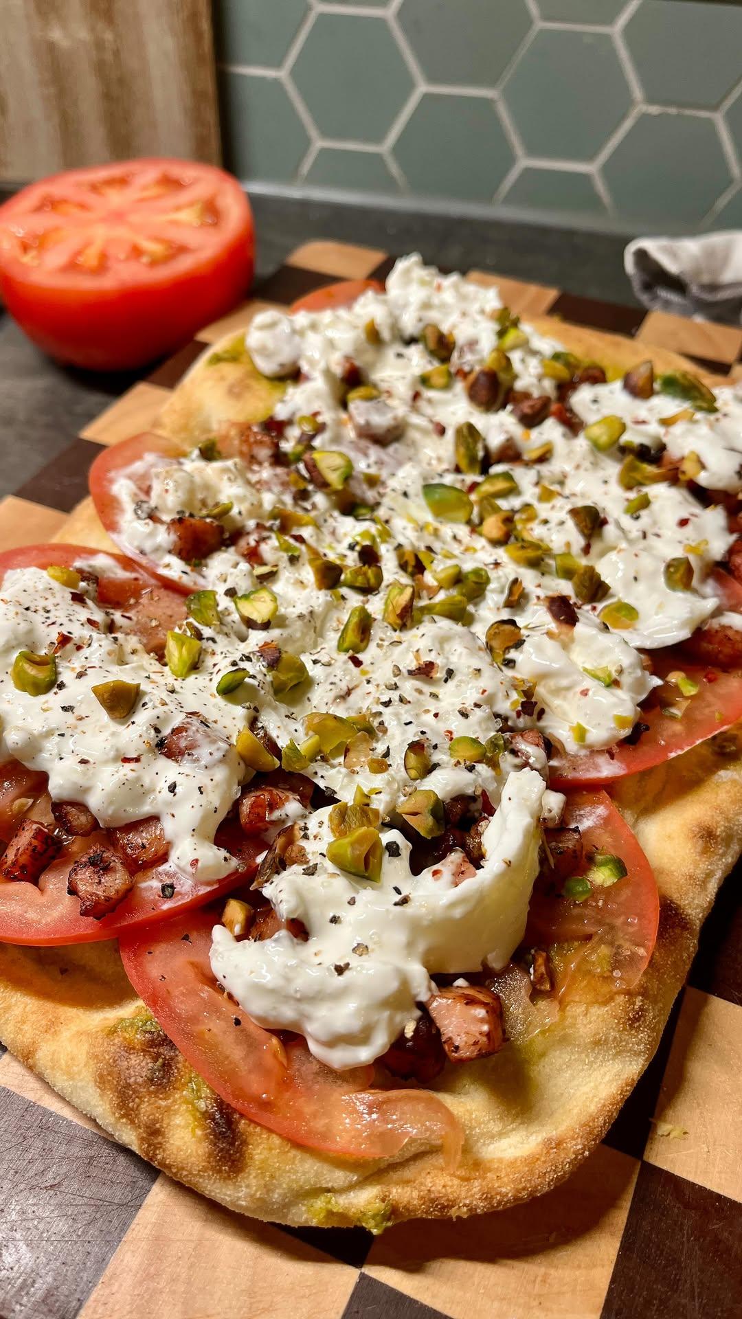 Pinsa met burrata, spekjes en pistachenoten